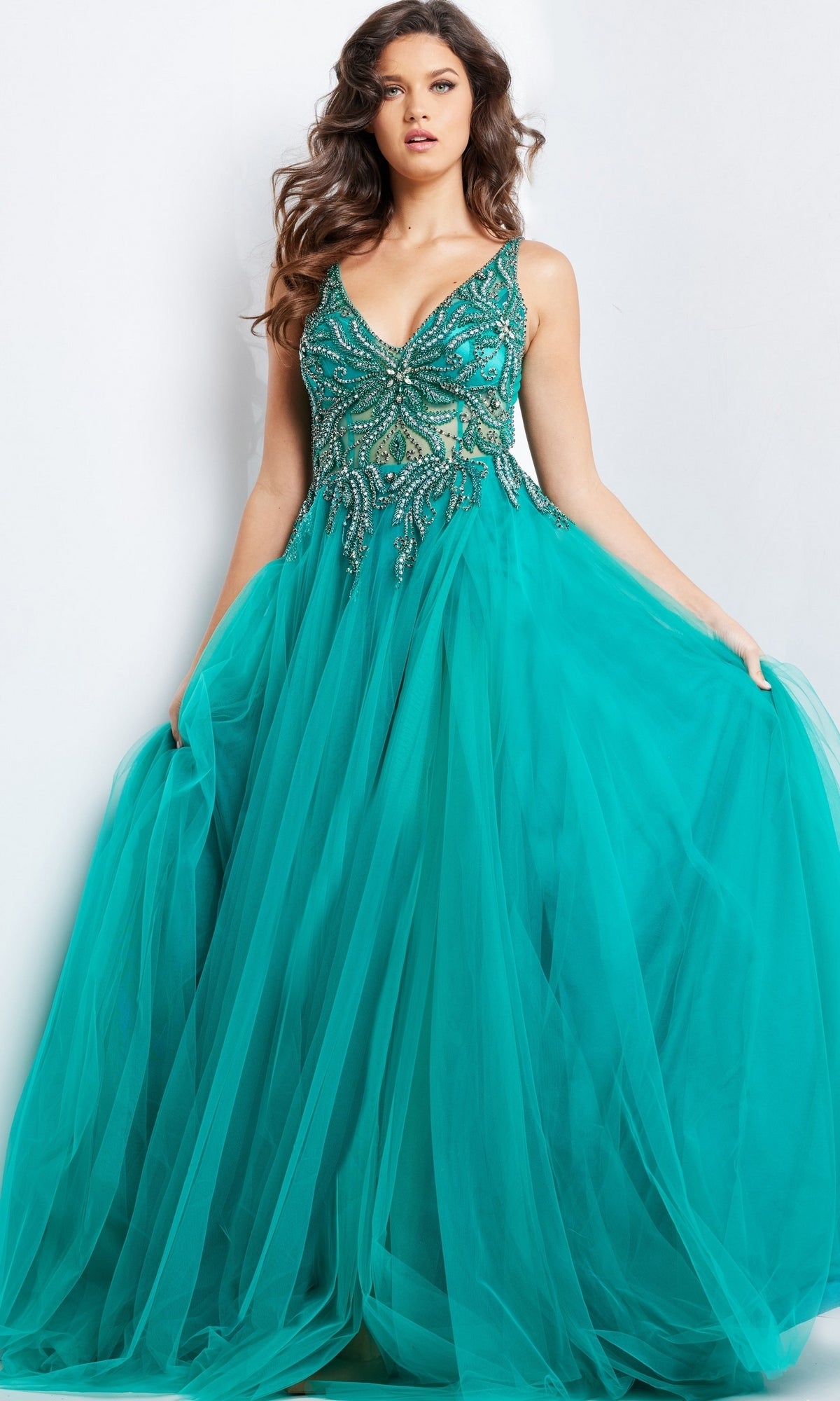 A woman models the Jovani Beaded-Bodice Long Prom Ball Gown 23962 in teal, featuring a sleeveless design, beaded bodice, and full tulle skirt, standing against a plain white background.